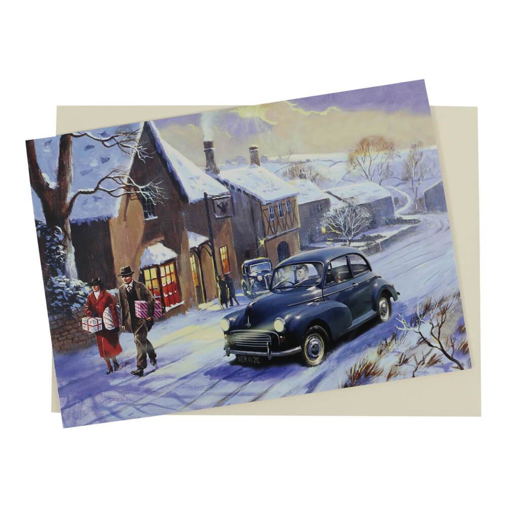 This traditional style Morris Minor Christmas card features a Morris classic car a festive snow-covered village setting.